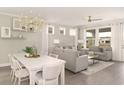 Inviting living room features two sofas, a decorative ceiling fan, and large windows at 332 Dahlia Row Dr, Summerville, SC 29486