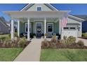 Inviting home featuring a charming front porch adorned with stylish decor and lush, manicured landscaping at 3522 Habenaria Rd, Mount Pleasant, SC 29466