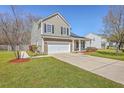 Side view of a two-story tan home with a two-car garage, landscaped lawn and a concrete driveway at 4979 Ballantine Dr, Summerville, SC 29485