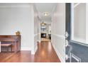 Elegant entryway with hardwood floors, arched doorway, decorative molding and trim, and view to living room with fireplace at 5409 Clairmont Ln, North Charleston, SC 29420