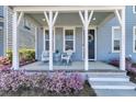 Inviting covered porch with seating, beautiful plantings and stylish decorations at 565 Blueway Ave, Summerville, SC 29486