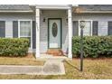 Inviting entryway featuring a classic white door flanked by windows and trimmed shrubbery at 8458 William Moultrie Dr, North Charleston, SC 29420