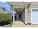 Inviting entrance of home featuring covered walkway to front door and attached garage at 9021 Delancey Cir, North Charleston, SC 29406