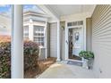 Charming front entrance with white columns, flower accents, and a decorative glass door at 9021 Delancey Cir, North Charleston, SC 29406