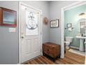 Inviting entryway featuring wood floors, a decorative door, and a glimpse into a half-bathroom with stylish decor at 103 Avalon Ct, Goose Creek, SC 29445