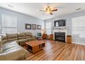 Spacious living room with a fireplace, wood-look flooring, a sectional couch, and ample natural light at 103 Avalon Ct, Goose Creek, SC 29445