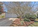 Two-car garage sits on a manicured lawn under a picturesque tree at 1127 Tidal View Ln, Charleston, SC 29412