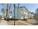 Side view of a two-story home showcasing the light blue siding, porch and walkway at 114 E Respite Ln, Summerville, SC 29483