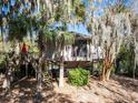 Charming elevated exterior featuring wooden deck, stairs and mature trees at 12 Dune Crest Trace Trl, Seabrook Island, SC 29455