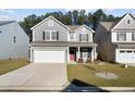 Charming two-story home with gray siding, well-manicured lawn, and a two car attached garage at 128 Surfbird Rd, Summerville, SC 29486