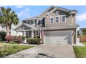 Inviting two-story home featuring an attached two-car garage and lush landscaping at 146 Education Blvd, Ladson, SC 29456