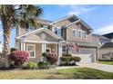 Attractive two-story home featuring an attached two-car garage, front yard, and landscaping at 146 Education Blvd, Ladson, SC 29456