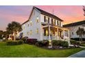 Side view of a two-story home showcasing the manicured lawn, lush landscaping, and inviting front porch at sunset at 1525 Harriman St, Mount Pleasant, SC 29466