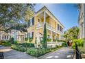 Charming two-story yellow house with a beautiful landscaped yard, wrought iron fence, and inviting front porch at 171 Broad St, Charleston, SC 29401