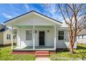 Inviting front porch with brick steps, offering a shaded retreat with a view of the landscaped yard at 2120 Thornlee Dr, North Charleston, SC 29405