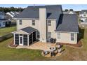 Spacious backyard with a fire pit, seating area, screened porch, and lush green lawn perfect for outdoor enjoyment at 219 Daybreak Blvd, Summerville, SC 29486