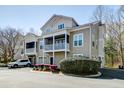 Exterior view of a multi-story condo with a large porch, garage, and beautifully landscaped surroundings at 2434 Egret Crest Ln, Charleston, SC 29414