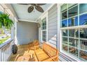 Inviting covered porch with comfortable seating, ceiling fan, and charming decorative lanterns at 312 Coki Amalie Ct, Charleston, SC 29492