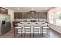 Bright kitchen features a large island with seating, stainless steel appliances, and ample cabinet space for storage and meal preparation at 332 Calm Water Way, Summerville, SC 29486