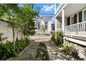 Beautiful brick driveway leading to a white carriage house, framed by lush greenery at 34 Anson St, Charleston, SC 29401