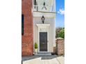 Charming front door framed by classic brick and cream siding, with elegant lighting and greenery at 34 Anson St, Charleston, SC 29401
