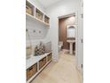 Well-organized mudroom featuring a built-in bench with storage baskets and adjacent powder room at 356 Claret Cup Way, Charleston, SC 29414