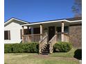 Inviting covered front porch with brick accents and well-maintained landscaping at 391 Furman Ln, Ladson, SC 29456