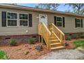 A charming house featuring new wood steps and a well-manicured yard with vibrant flowers and lush greenery at 413 Peacock Ln, Summerville, SC 29486