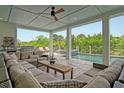 Luxurious covered patio with comfortable seating, grill, and a view of the pool and outdoor spa at 4874 Sound View Dr, Mount Pleasant, SC 29466