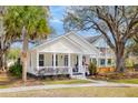 Charming home with a welcoming front porch and mature trees, offering a serene and inviting curb appeal at 5108 Celtic Dr, North Charleston, SC 29405