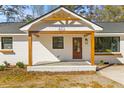 Inviting front porch with stained wood supports and white trim welcomes you to this charming home at 671 Riley Rd, Charleston, SC 29412
