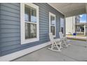 View of front porch with blue siding and two white rocking chairs at 69 Arrowwood Way, Summerville, SC 29485