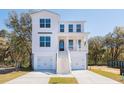 Beautiful three-story coastal home with a double garage, covered porch, and manicured lawn at 716 Minton Rd, Charleston, SC 29412