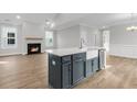Modern kitchen island featuring a farmhouse sink and stainless-steel appliances open to a living room with a fireplace at 718 Minton Rd, Charleston, SC 29412