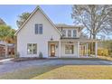 Elegant two-story home with a covered porch, wooden door, and well-manicured landscaping at 755 Adluh St, Mount Pleasant, SC 29464