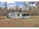 Exterior view of a white house with green trim and a screened in porch in a grassy lot with trees at 7560 Cottageville Hwy, Round O, SC 29474