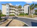 Exterior of the building showing its multiple balconies and access to upper floors, plus lush landscaping at 9000 Palmetto Dr # G203, Isle of Palms, SC 29451