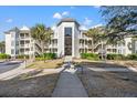 Exterior view of the building showcasing its architectural design and multiple balconies with steps at 9000 Palmetto Dr # G203, Isle of Palms, SC 29451