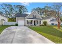 Inviting home showcases a manicured lawn, lengthy concrete driveway, and serene, tree-lined surroundings at 9116 Fieldstone Trace, Summerville, SC 29485