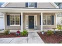 The front entrance features a charming porch, adorned with decorative accents, and colorful landscaping at 9116 Fieldstone Trace, Summerville, SC 29485
