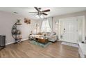 Inviting living room with hardwood flooring, comfortable seating, modern ceiling fan, and sunlit windows at 9116 Fieldstone Trace, Summerville, SC 29485