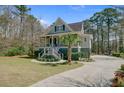 Inviting home exterior featuring a landscaped yard, a graceful palm tree, and a spacious driveway at 1014 Bradbury Ln, Charleston, SC 29492