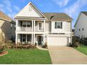 Charming two-story home featuring a covered porch, attached garage, and well-manicured lawn at 116 Rouen Ln, Summerville, SC 29486