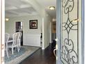 View through decorative glass-accented front door into entry, dining room with table, and kitchen at 116 Rouen Ln, Summerville, SC 29486