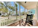 Relaxing front porch with wooden flooring, classic rocking chairs, and views of the neighborhood at 1429 Lettered Olive Ln, Mount Pleasant, SC 29464
