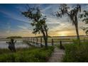 Picturesque landscape featuring a wooden walkway leading over the wetlands and a serene sunset view at 1456 Mcpherson Lndg, Johns Island, SC 29455