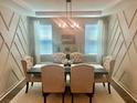Formal dining room featuring elegant wainscoting, a stylish chandelier, and large windows for natural light at 150 Haverhill St, Summerville, SC 29486