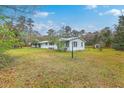 Front exterior view with a well-maintained lawn, complementing the cozy single-story home and trees at 1644 Cooper Store Rd, Moncks Corner, SC 29461