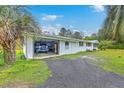Attached garage featuring a vehicle, open garage door, and palm trees, offering ample parking at 1644 Cooper Store Rd, Moncks Corner, SC 29461