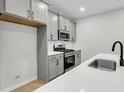 Modern kitchen with stainless steel appliances, gray cabinets, and sleek quartz countertops at 169 Cantona Dr, Summerville, SC 29483